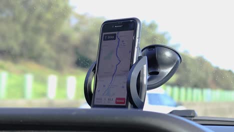 phone gps navigating on car dashboard while driving on a sunny day