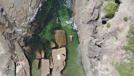 birds eye pov shot of a person bathing in rockpool