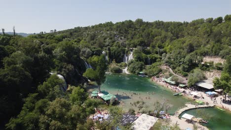 paradisiac waterfall of kravica in bosnia and herzegovina, crowded lake, summer