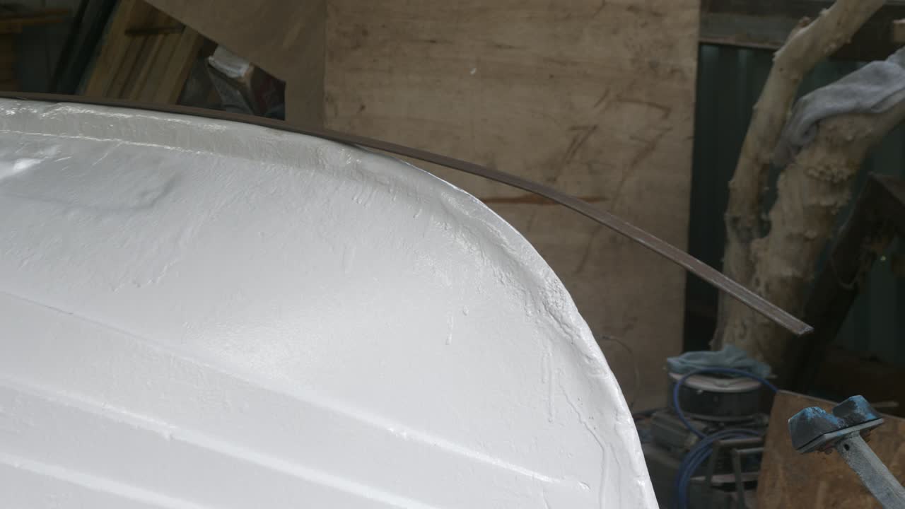 New keel band sitting on upturned fiberglass fishing boat bow