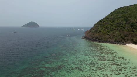 Ascending-aerial-4k60-view-of-Coral-Island-shoreline,-Andaman-Sea-and-islands-in-distance