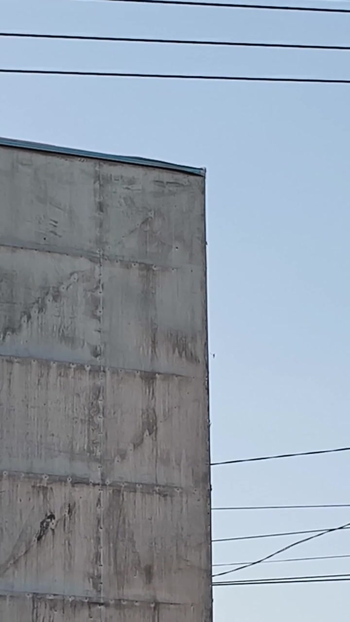 Esquina de edificio de hormigón contra cielo azul claro