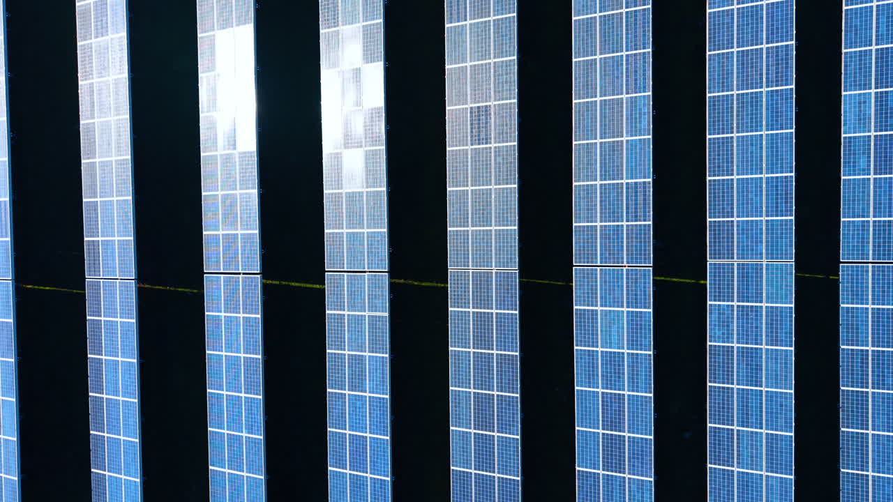 Close up top view of solar panels texture. Detailed aerial perspective of blue photovoltaic cells reflecting sunlight in a structured pattern