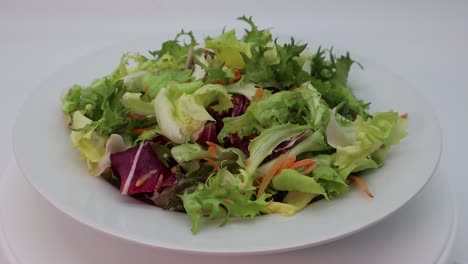 fresh mixed green salad in a bowl rotating