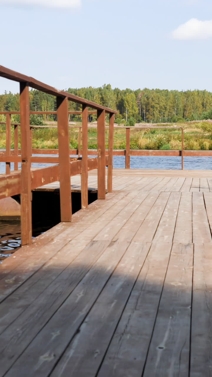 muelle de madera en un río con fondo forestal