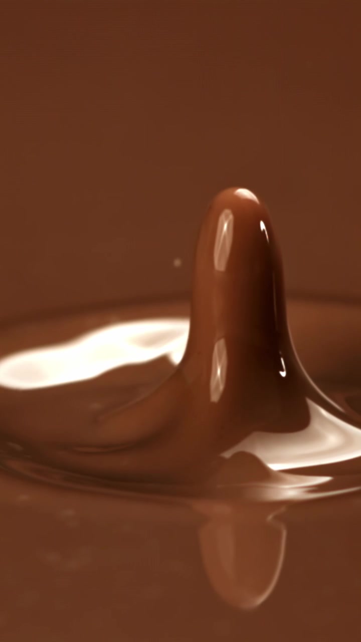 Goccia di cioccolato che schizza su una superficie liquida al rallentatore