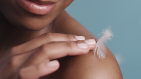 close up beauty portrait beautiful african american woman feathers falling on smooth skin touching bare shoulders soft natural skincare gently caressing body slow motion