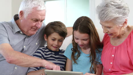 grandparents and grandchildren using tablet