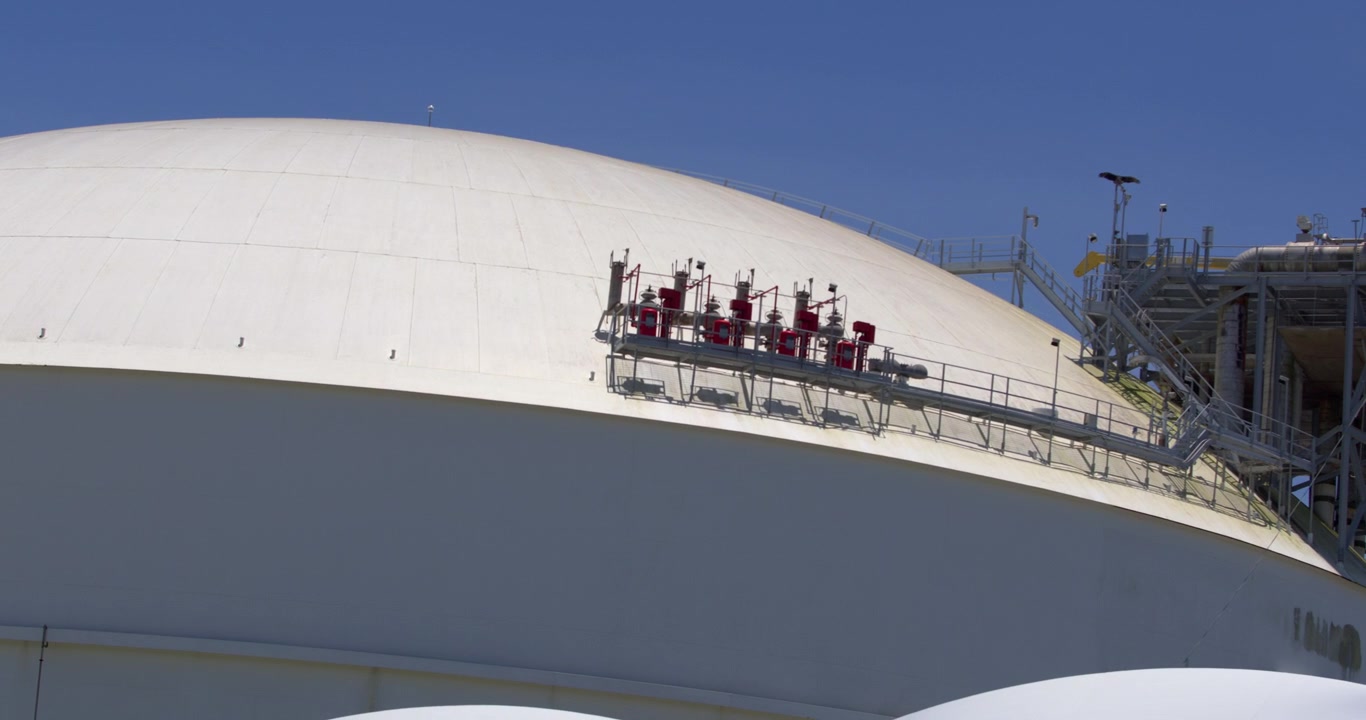 Daytime eye level panning shot showing industrial pipes, valves, and storage infrastructure at Coastal Petroleum Dominicana terminal in San Pedro de Macoris, Dominican Republic