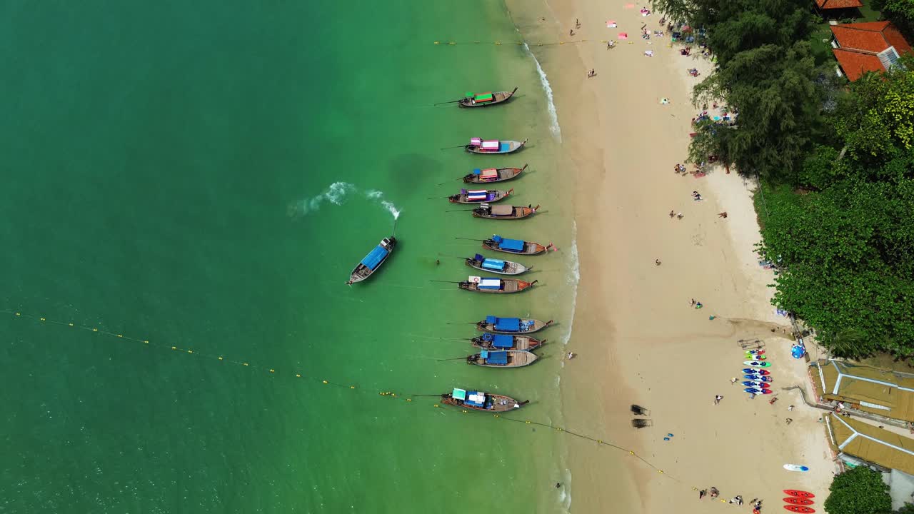 Traditional Thai longtail boats moored on Railay Beach Thailand, aerial drone view