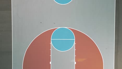 Aerial-drone-bird's-eye-view-over-colorful-basketball-court-on-a-sunny-day