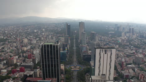 Backwards-reveal-of-long-straight-boulevard-lined-by-skyscrapers.-Cloudy-sky-before-rain-or-storm-Mexico-City,-Mexico.