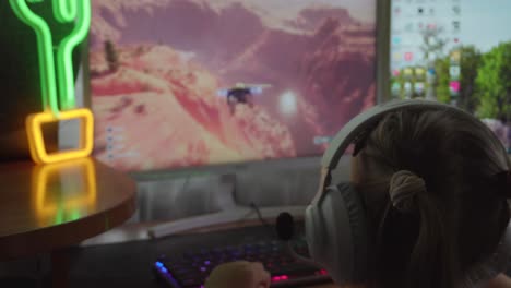 joven niña jugando en una computadora, pc jugando con auriculares blancos en