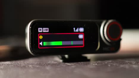 close view of oled screen of wireless mic receiver show variety of display icons like volume, battery level and frequency