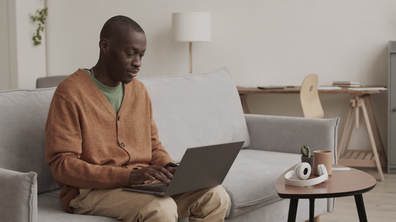 African-American Handsome Man Sitting on Sofa with Laptop