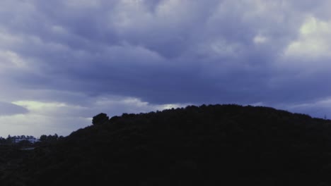 cloudy day timelapse with hill in silhouette