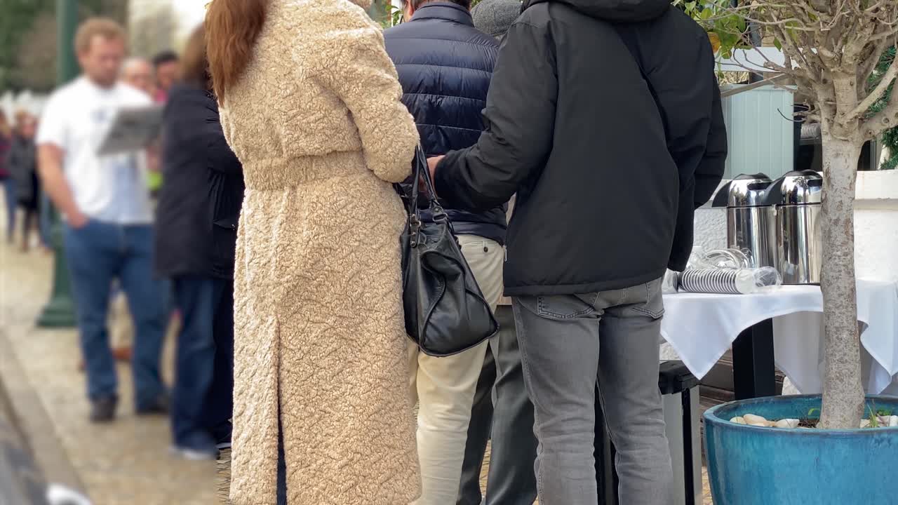 사람들이 줄을 서거나 줄을 서서 기다리고 있다