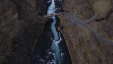 drone volando sobre la cascada de bruararfoss en el paisaje rural, islandia