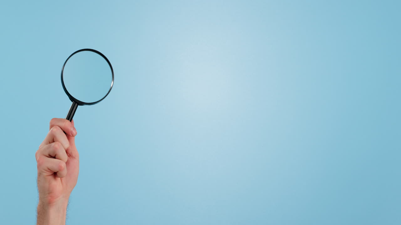 fondo azul, mano y una lupa