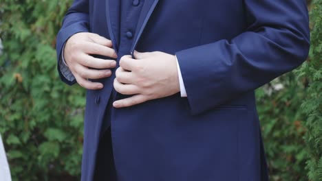 groom gets ready and buttons suit