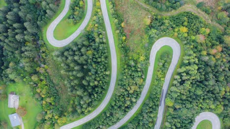 Vista-Aérea-De-La-Carretera-Rural-Que-Atraviesa-El-Bosque-Verde-Y-La-Montaña