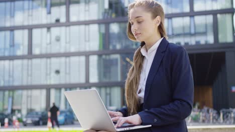 Formal-woman-with-laptop-on-street