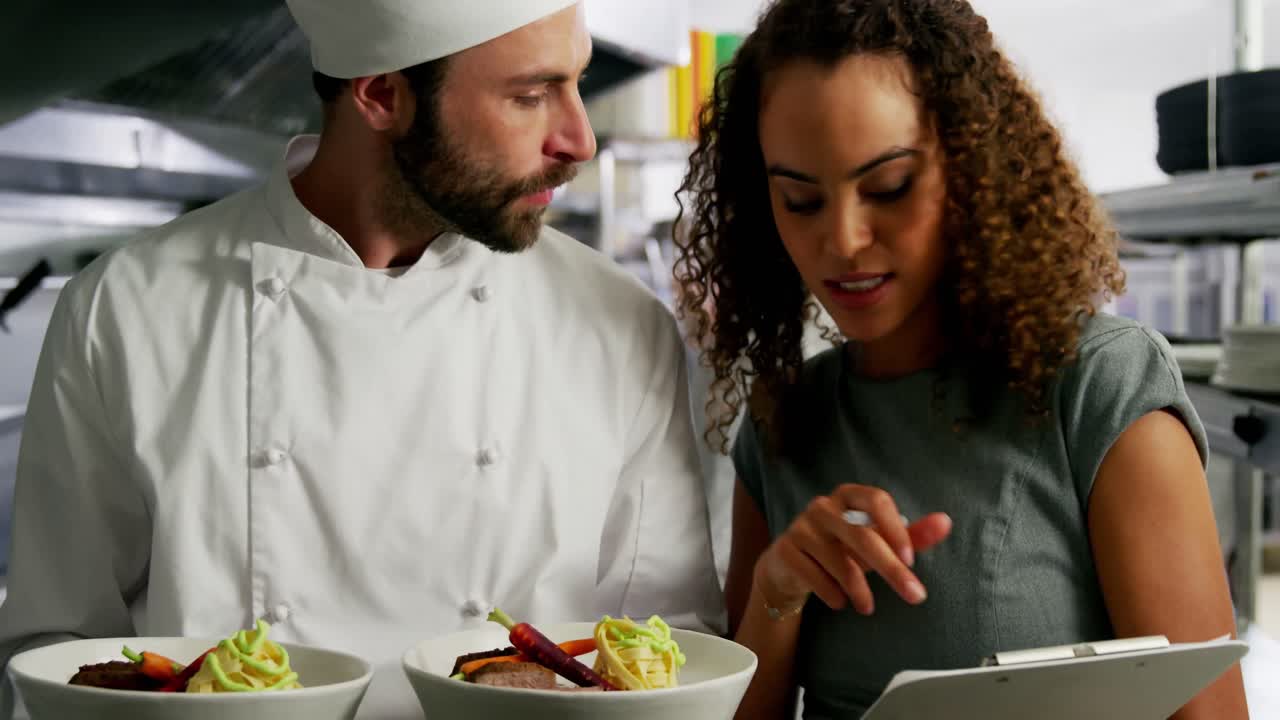 chef llevando platos de comida interactuando con el gerente del restaurante