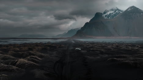 Drohnenaufnahmen-über-Dem-Schwarzen-Sandstrand-Von-Stokksnes-Mit-Dramatischen-Wolken-Und-Dem-Majestätischen-Berg-Vestrahorn,-Island