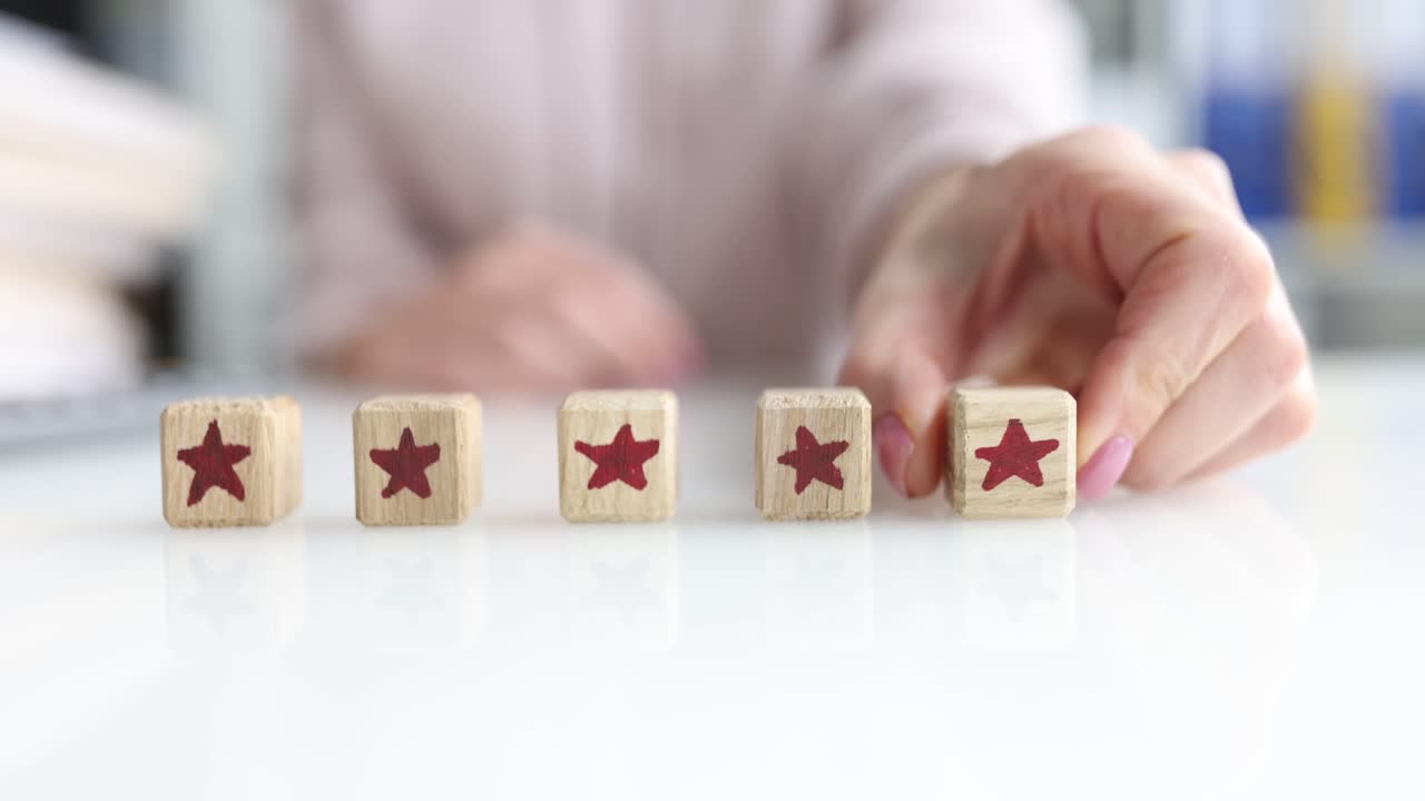Woman hand puts awooden cube with star symbol on table