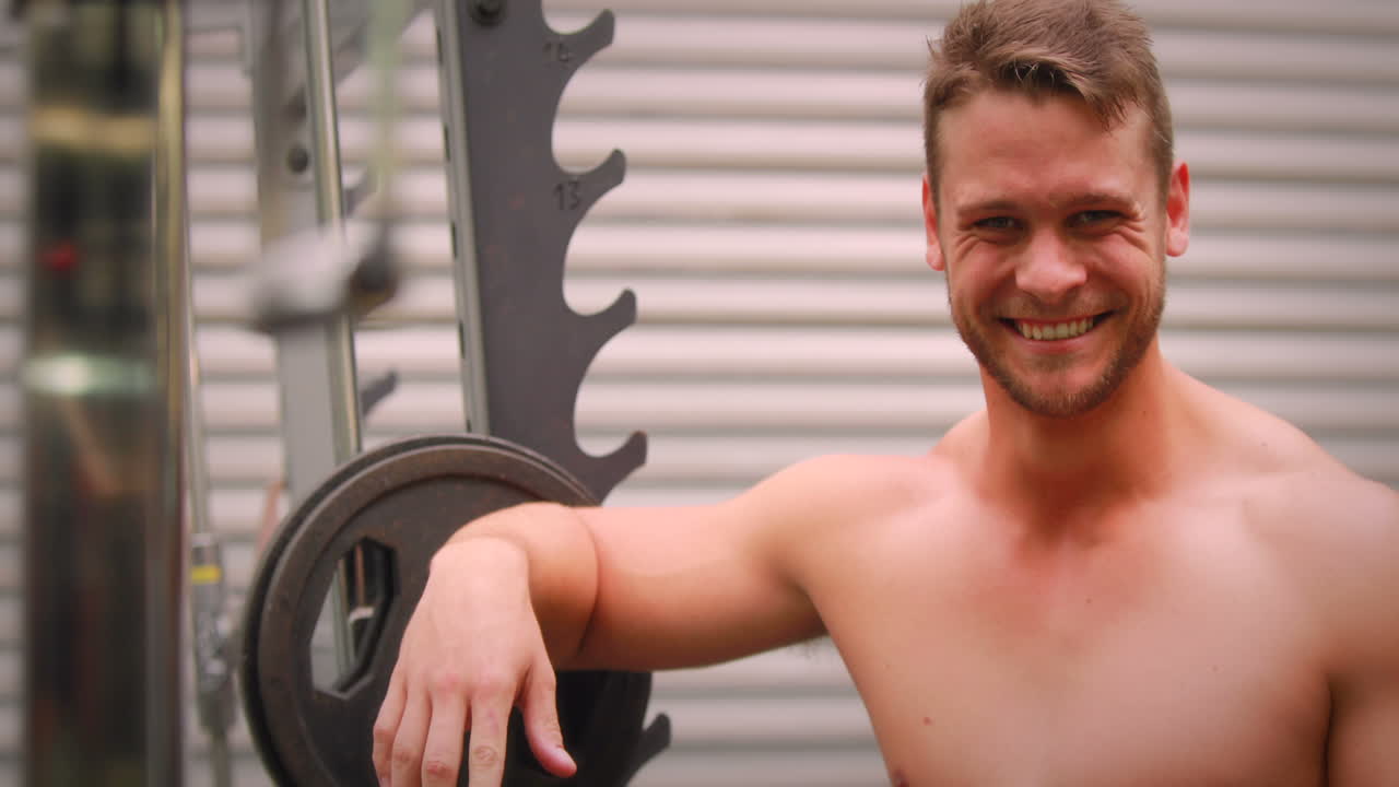hombre musculoso poniendo sus pesas en el gimnasio crossfit