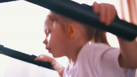 little girl in white tshirt runs on 2 running machine at home