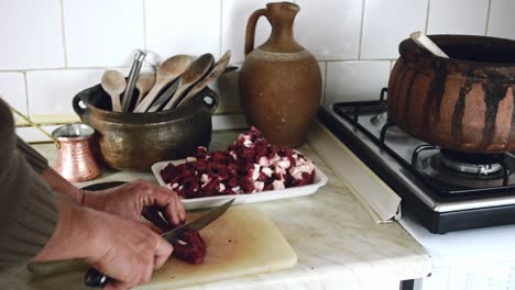 senior turkish man sharpens his knife and chops liver meat to serve in iftar in ramadan month with an authentic kitchen