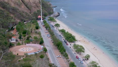 families relaxing, playing and having fun on the weekend at white sandy beach with beautiful turquoise water ocean in the capital dili, timor leste, southeast asia