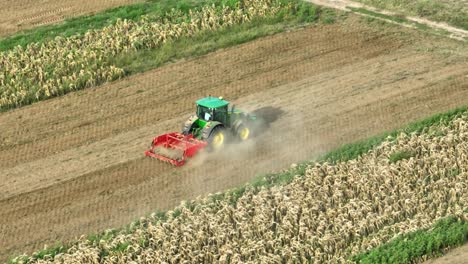 Tiro-De-Seguimiento-Aéreo-Del-Campo-De-Cultivo-De-Arado-De-Tractor-Industrial-Verde