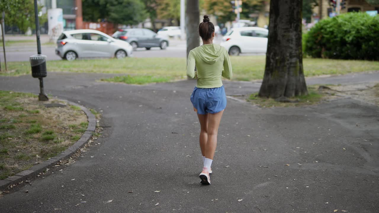 mujer corriendo en un parque de la ciudad