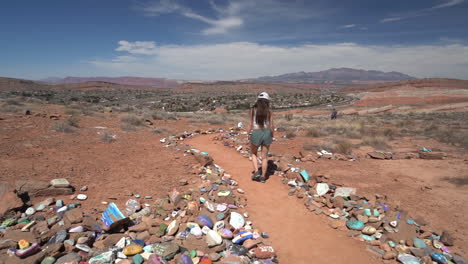 mujer joven caminando entre rocas de color en el sendero de senderismo de punto de aspiración, st