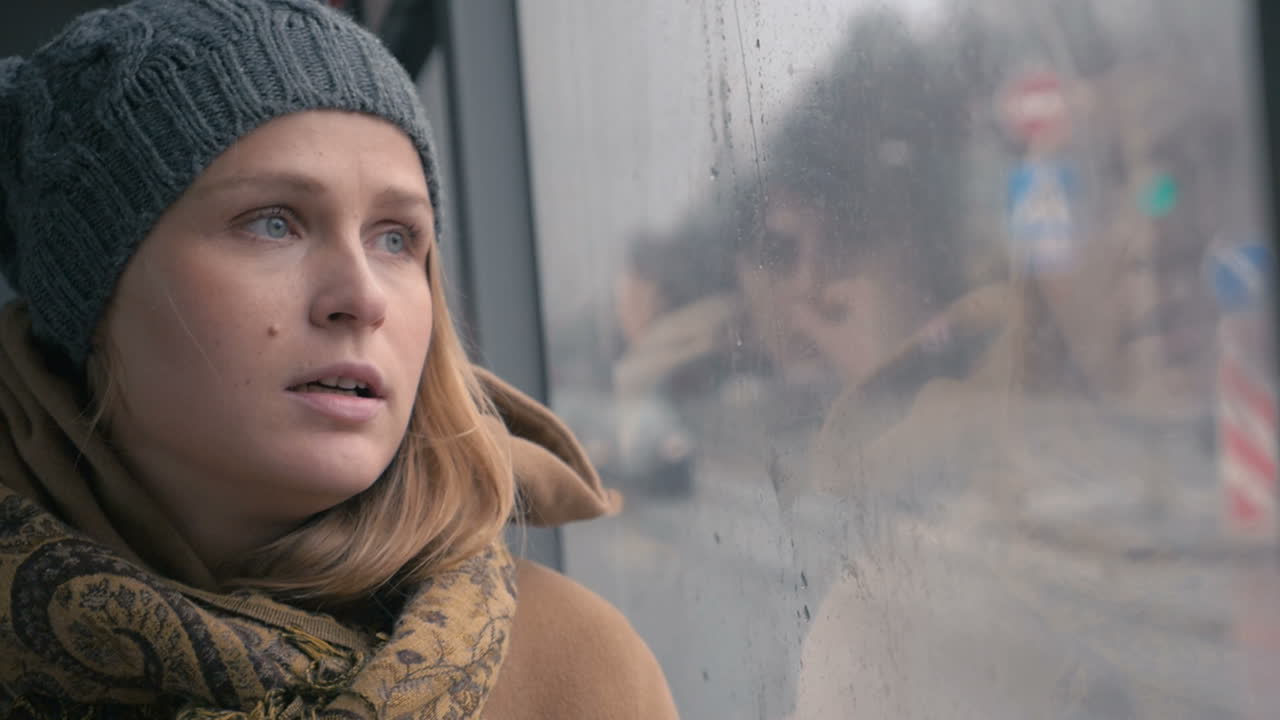 Young sad woman in the bus on a dull rainy day