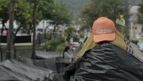 rehab cap drying over plastic tent at venezuelan migrant camp in bogota - colombia
