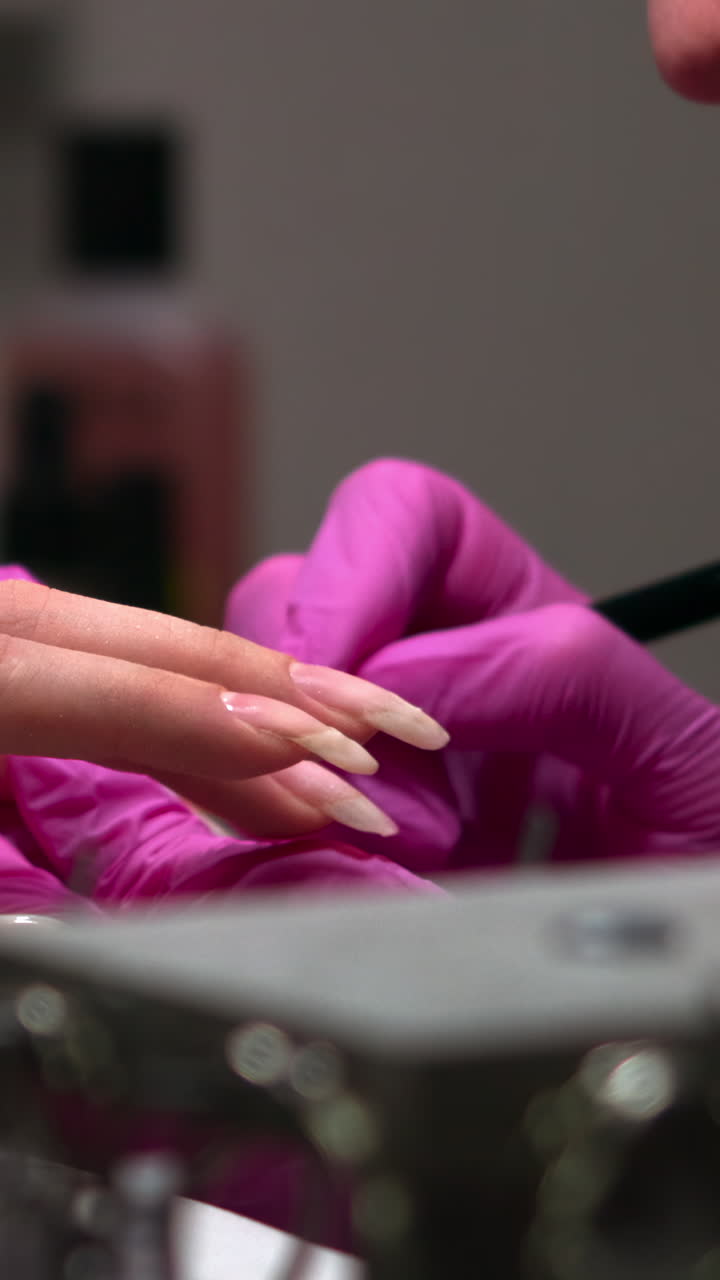 Manicurist in Pink Gloves Applying Nail Polish to Client's Long Nails
