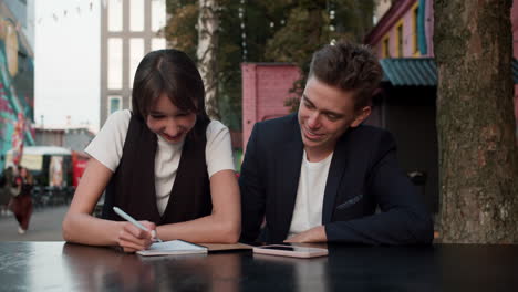 teenage boy and girl writing outdoors