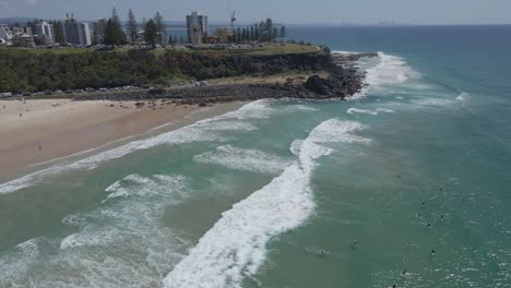 rascacielos cerca del mirador de peligro y surfistas en la playa de duranbah en gold coast, australia