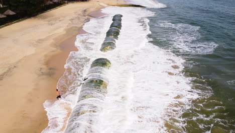 Tubo-Geo-Cubierto-De-Musgo-En-La-Playa-Costera-De-Arena-De-Vietnam-Para-Proteger-La-Tierra-De-Las-Olas-Del-Océano