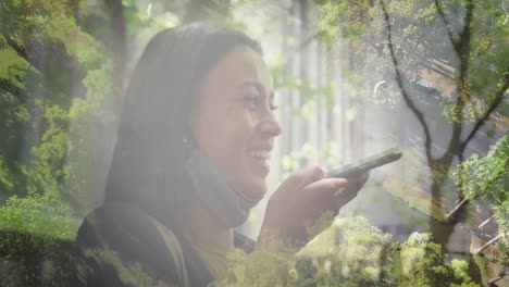 Animación-De-Una-Mujer-Feliz-De-Raza-Mixta-Usando-Un-Teléfono-Inteligente-Sobre-El-Paisaje.