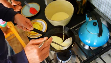 hombre preparando panqueques en la cocina 4k