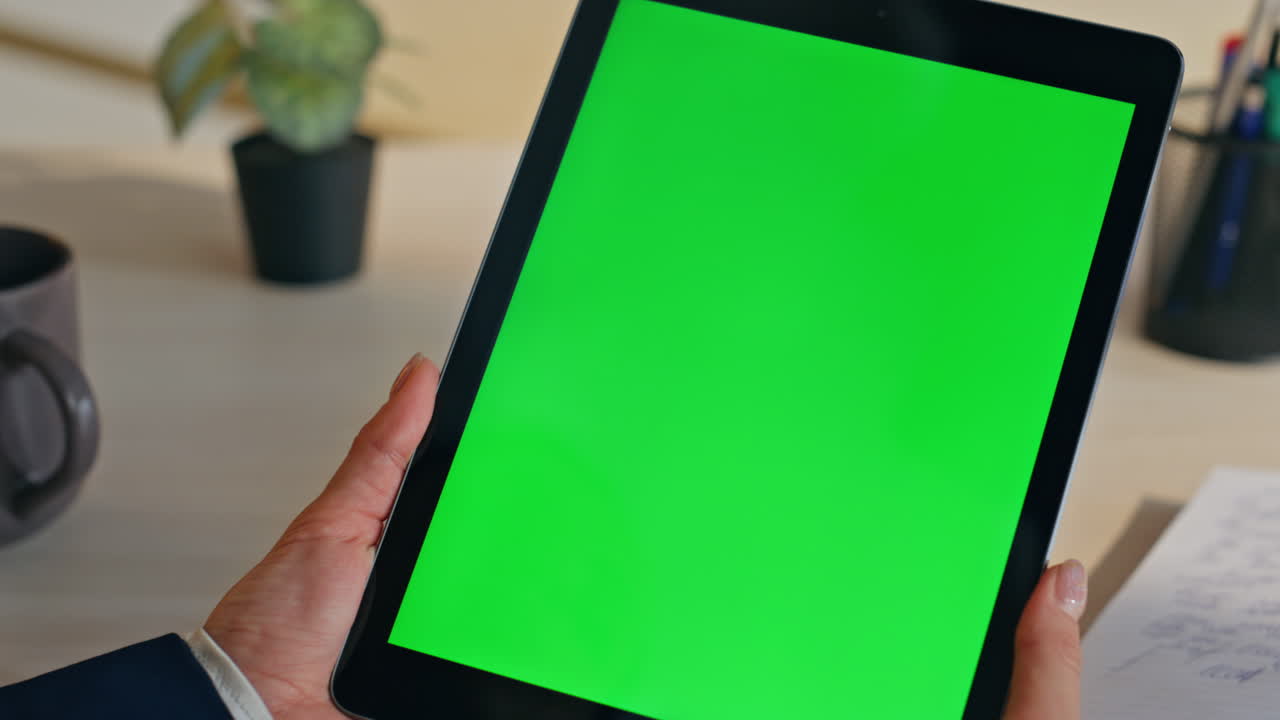Unknown student watching chromakey tablet sitting at modern work desk closeup
