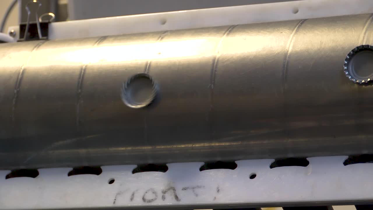 Bottle caps rotating on a magnetic cylinder and placed into compartments ready for bottling