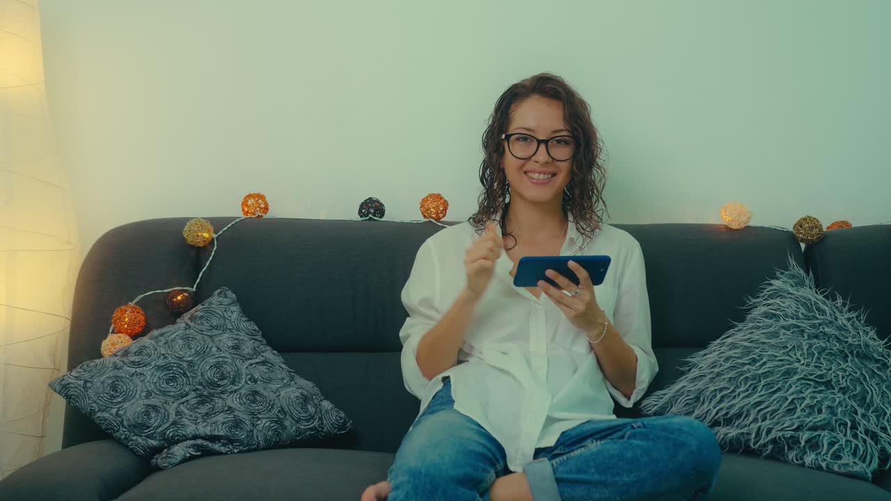 Woman Relaxing on Sofa with Smartphone