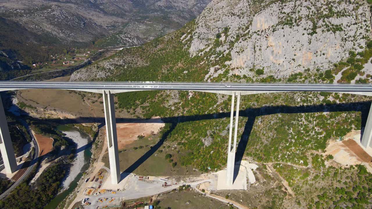 воздушный снимок полностью законченного моста морасика в черногории. большой красный герб черногории виден на одном из столбов моста