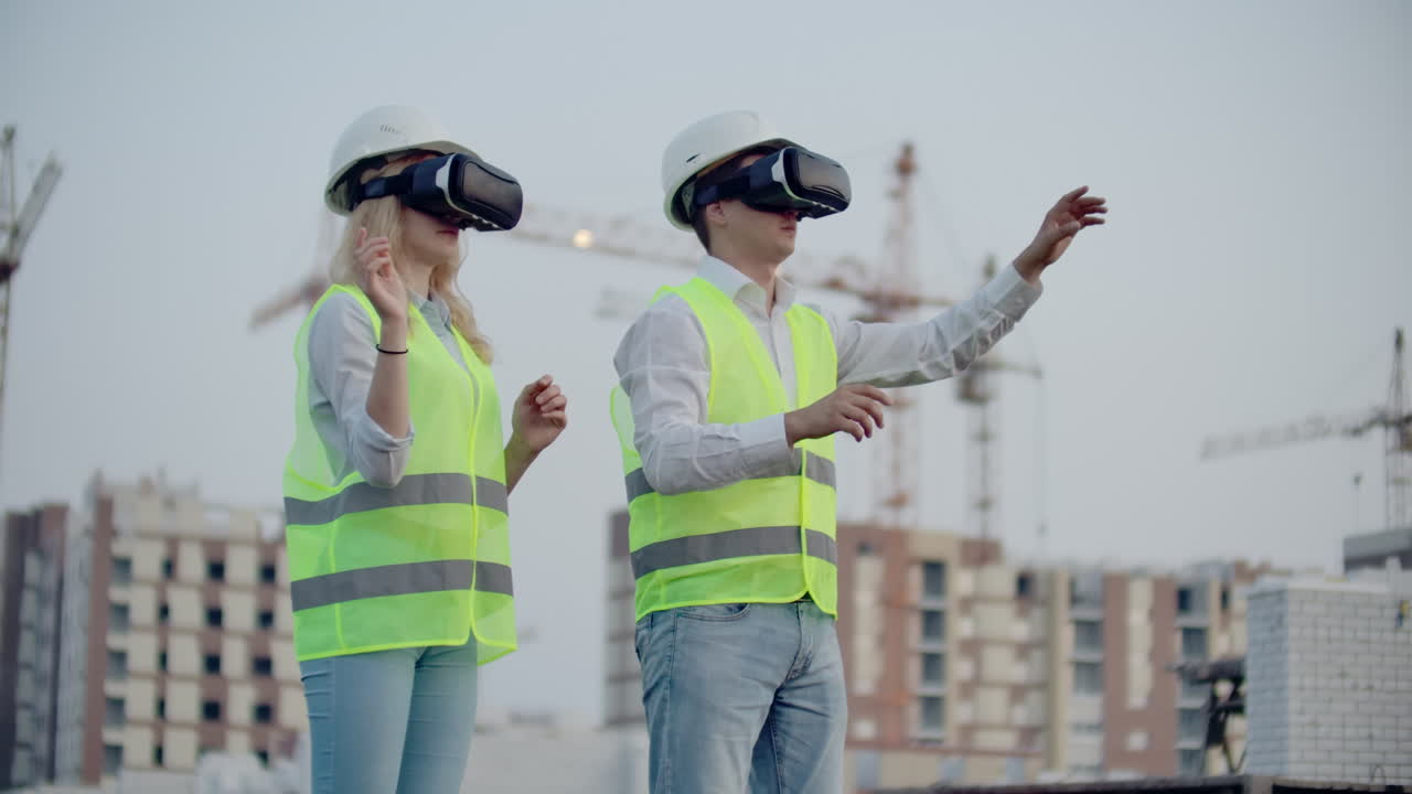 dos personas en gafas de realidad virtual en el fondo de edificios en construcción con grúas imitan el trabajo de la interfaz para el control y la gestión de la construcción.