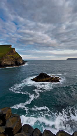 dramatic waves crashing on basalt columns at a rugged coastline